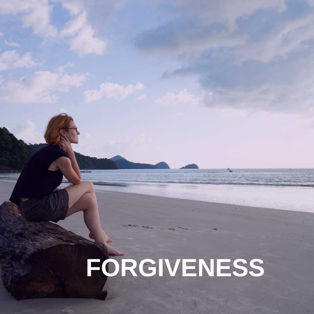 woman sitting on a beach woman sitting on beach thinking forgiveness